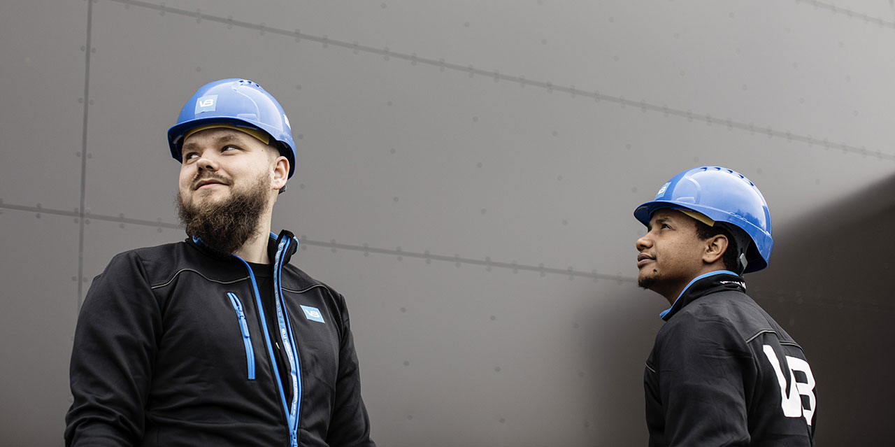 VB-rørleggere står sammen ved et bygg